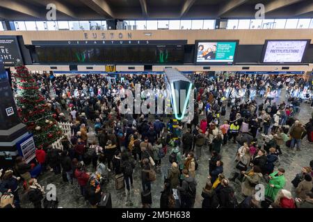 Les passagers regardent les panneaux d'affichage à la gare d'Euston à Londres à la suite d'une grève des membres de l'Association du personnel des transports salariés (TSSA). Date de la photo: Jeudi 29 décembre 2022. Banque D'Images