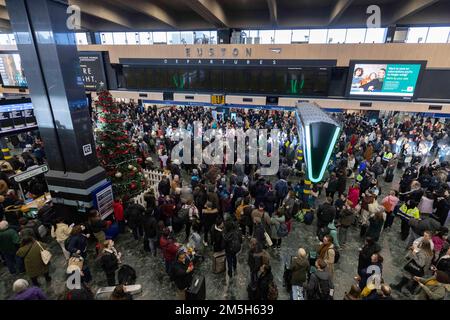 Les passagers regardent les panneaux d'affichage à la gare d'Euston à Londres à la suite d'une grève des membres de l'Association du personnel des transports salariés (TSSA). Date de la photo: Jeudi 29 décembre 2022. Banque D'Images