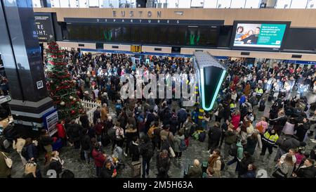 Les passagers regardent les panneaux d'affichage à la gare d'Euston à Londres à la suite d'une grève des membres de l'Association du personnel des transports salariés (TSSA). Date de la photo: Jeudi 29 décembre 2022. Banque D'Images
