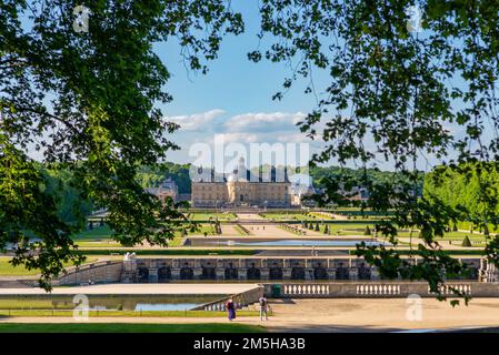 Maincy, France - 21 mai 2022 : une vue encadrée d'arbres d'un château s'établit sur la perspective principale d'un jardin classique français (Vaux-le-Vicomte). Photo Banque D'Images