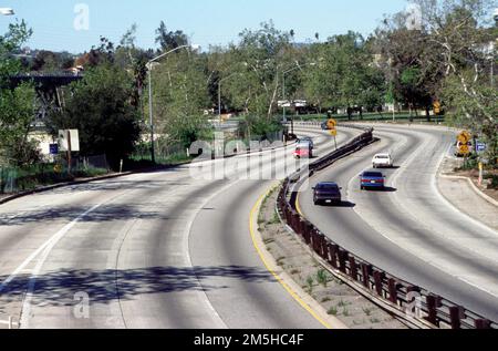 Arroyo Seco Historic Parkway - route 126 - Arroyo Seco Parkway avec pont ferroviaire historique. Cette vue typique de la promenade montre 6 voies, un alignement courbe, des sycomores indigènes et le pont ferroviaire historique LA-Pasadena en arrière-plan. Lieu: Pasadena, Californie (34,086° N 118,214° O) Banque D'Images