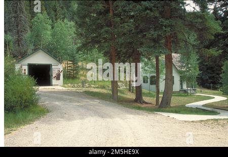 La boucle de l'énergie: Huntington/Eccles Canyons route panoramique - Stuart Guard Station. Des arbres bordent l'allée et s'élèvent derrière le terrain de la station de la Garde Stuart en été. Emplacement : Utah Banque D'Images