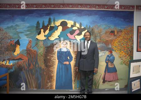 Harriet Tubman Underground Railroad Byway - debout devant la fresque de l'organisation Harriet Tubman. Le président de l'organisation Harriet Tubman, Donald Pinder, se dresse devant une fresque artistique folklorique vibrante représentant la vie de Tubman. Le Harriet Tubman Organization Museum, Maryland Banque D'Images