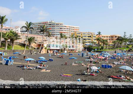 Beach Arena avec beaucoup de vacanciers sur le sable noir volcanique à Puerto de Santiago sur Tenerife, îles Canaries, Espagne. Banque D'Images