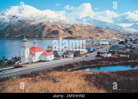 Route maritime de l'Alaska - Histoire et paysage d'Unalaska. Le toit rouge et vert d'une église de style russe orthodoxe apporte une touche de couleur au paysage montagneux d'hiver dans cette scène d'Unalaska. Lieu: Unalaska, Alaska Banque D'Images
