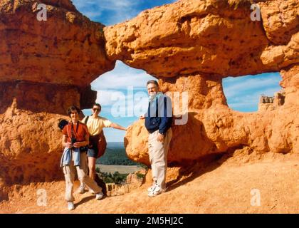 Pittoresque Byway 12 - Keyhole Arch. Trois visiteurs se posent devant l'arche de Keyhole. Emplacement : Utah (37,749° N 112,328° O) Banque D'Images