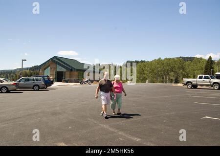 Logan Canyon Scenic Byway - dans le lac de l'Ours donnent sur le parking. Deux visiteurs se promènent de l'autre côté du parking pour avoir une vue plus rapprochée de Bear Lake depuis la vue. Emplacement : Bear Lake Overlook, Logan Canyon, Utah (41,921° N 111,458° O) Banque D'Images