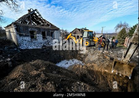 STEPNE, UKRAINE - 29 DÉCEMBRE 2022 - des excavateurs sont vus à l'extérieur d'une maison détruite lors d'une attaque russe de missiles S-300 sur le village de Stepne, Zaporizhzhia Banque D'Images