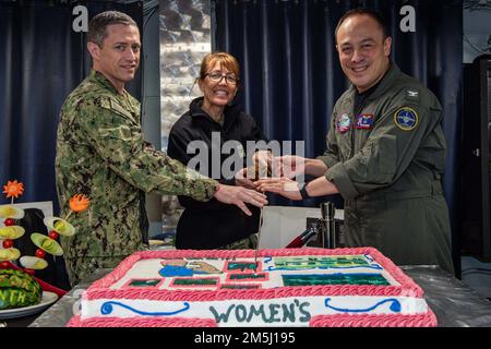 220318-N-SI601-1078 YOKOSUKA, Japon (18 mars 2022) Capt Carolyn Rice, commandant des États-Unis Hôpital naval de Yokosuka, au milieu, le capitaine Fred Goldhammer, commandant des États-Unis Le seul porte-avions déployé par l’avant de la Marine, l’USS Ronald Reagan (CVN 76), à droite, et le chef de commandement Chris King ont coupé un gâteau du mois de l’histoire des femmes lors d’une célébration sur les ponts arrière du mess. L’événement de cette année a mis en lumière les réalisations des femmes tout au long de l’histoire et dans le monde d’aujourd’hui, et s’est concentré sur le thème « les femmes qui fournissent la guérison, promeuvent l’espoir ». Ronald Reagan, le fleuron de Carrier Strike G. Banque D'Images