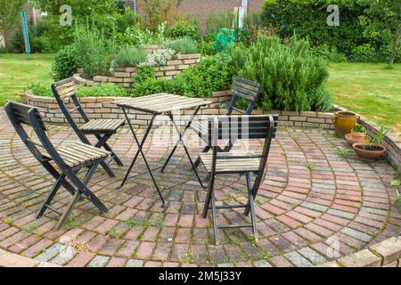 spirale d'herbes dans le jardin et table avec chaises Banque D'Images