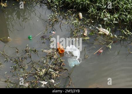 Petite voie navigable remplie de déchets de plastique, de sacs en polyéthylène et de plantes de mauvaises herbes au Sri Lanka Banque D'Images