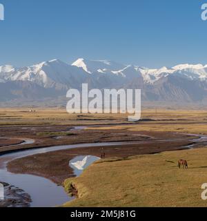 Vue sur le paysage le matin de la spectaculaire chaîne de montagnes Trans-Alai ou Trans-Alay enneigée avec réflexion sur la rivière Kyzylsu dans le sud du Kirghizistan Banque D'Images