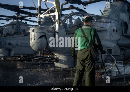 OCÉAN ATLANTIQUE – le Cpl Matthew Buffaloe, mécanicien de cellule affecté au VMN-263, lave un hélicoptère AH-1Z Viper attaché à l'Escadron d'hélicoptères d'attaque légère marine (HMLA) 167, sur le pont de vol du navire d'assaut amphibie de classe Wasp USS Kearsarge (LHD 3), 19 mars 2022. Le Kearsarge Amphiobie Ready Group (ARG) et 22nd Marine Expeditionary Unit (MEU) opèrent dans l'océan Atlantique à l'appui des opérations navales visant à maintenir la stabilité et la sécurité maritimes afin d'assurer l'accès, de prévenir l'agression et de défendre les intérêts américains, alliés et partenaires. Banque D'Images