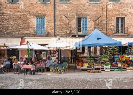 Italie rue café, vue en été des personnes assis à des tables de café dans une place pittoresque vieux marché, Piazza Sordello, Mantoue (Mantova), Lombardie, Italie Banque D'Images