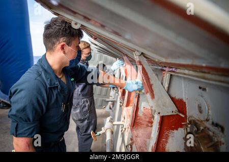 MER DES PHILIPPINES (19 mars 2022) le compagnon d'électricien Pompier romain Maytorena, à gauche, de Las Vegas, Et le Mate 2nd classe Bailey Watson d’Electricien, de Pinson, Alabama, prépare les prises de courant à terre pour la préservation à bord du destroyer à missiles guidés de classe Arleigh Burke USS Dewey (DDG 105) tout en effectuant des opérations de routine en cours dans la zone de responsabilité de la flotte américaine 7th. Dewey est affecté au Destroyer Squadron (DESRON) 15 et est en cours de soutien à un Indo-Pacific libre et ouvert. CTF 71/DESRON 15 est le plus grand DESRON déployé à l'avant de la Marine et le principal surfa de la flotte américaine 7th Banque D'Images