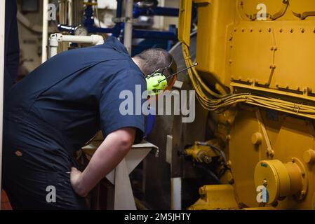 ÉTATS-UNIS Garde côtière Petty Officer 3rd classe Frank Aurelio, un compagnon d'électricien à bord du couteau de la Garde côtière Spar, vérifie le moteur en cours dans l'océan Atlantique, au 19 mars 2022. Spar et son équipage se rendent à Duluth, au Minnesota, après une période d'entretien d'un an à Baltimore. Banque D'Images