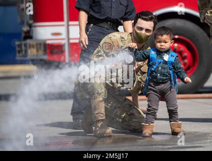 Le sergent d'état-major Alex Rowe, pompier de l'escadron 374th du génie civil, montre comment utiliser un tuyau d'incendie lors d'une visite de sensibilisation communautaire à la base aérienne de Yokota, Japon, 19 mars 2022. La base aérienne de Yokota entretient des relations avec ses dirigeants et communautés locaux voisins, car elle s'efforce de faire participer les aviateurs et les locaux à des visites informatives, à des événements de base et à des échanges culturels. Banque D'Images