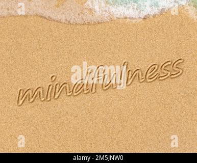 Concept de mindfulness, conscient vivant, du texte écrit sur le sable de plage Banque D'Images