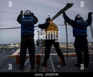 MER DE NORVÈGE (21 mars 2022) le compagnon de classe 3rd de Boatswain Clifford Turner, au centre, vérifie des cales et des chaînes avec des pilotes à bord d’un hélicoptère MH-60R Seahawk, attaché à l’escadron de frappe maritime d’hélicoptère (HSM) 79, à bord du destroyer à missiles guidés de classe Arleigh Burke USS Roosevelt (DDG 80), 21 mars 2022. Roosevelt, déployé à Rota, en Espagne, est en troisième patrouille aux États-Unis Sixième zone d'opérations de la flotte à l'appui des alliés et partenaires régionaux et des intérêts américains en matière de sécurité nationale en Europe et en Afrique. Banque D'Images