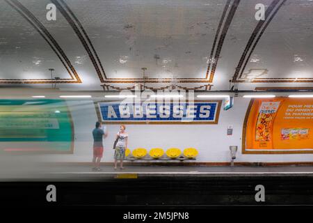 Paris, France - l'homme et la femme parlent sur la plate-forme en attendant le prochain train. Départ du train à blur à l'intérieur de la station de métro Abbesses à Montmartre. Banque D'Images