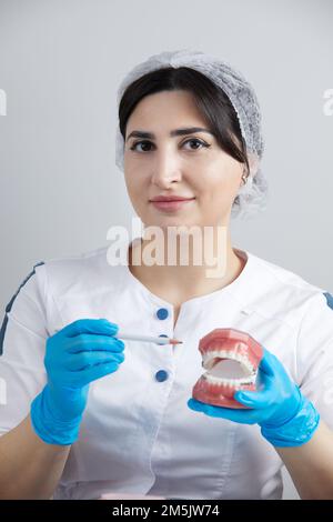 Orthodontiste montrant le modèle de la mâchoire humaine avec des étrésillons et des aligneurs de fil expliquant la différence Banque D'Images