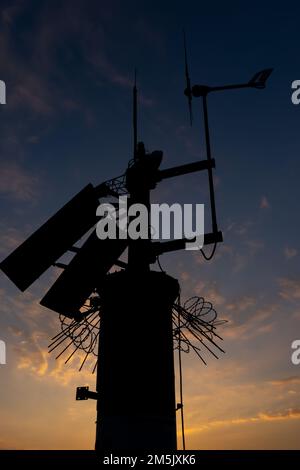 Station Meteo contre le soleil couchant. Éléments du système de surveillance continue des conditions météorologiques Banque D'Images