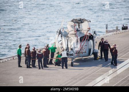 Les marins affectés aux “Tridents” de l’Escadron de combat de la mer (HSC) 9, assurent la sécurité d’un hélicoptère MH-60s Nighthawk attaché à HSC 9 sur le pont de vol de l’USS Gerald R. Ford (CVN 78), à 21 mars 2022. Ford est actuellement en cours dans l’océan Atlantique en train d’effectuer la certification de plate-forme de vol et les qualifications de transporteur d’ailes aériennes dans le cadre de la phase de base sur mesure du navire avant le déploiement opérationnel. Banque D'Images