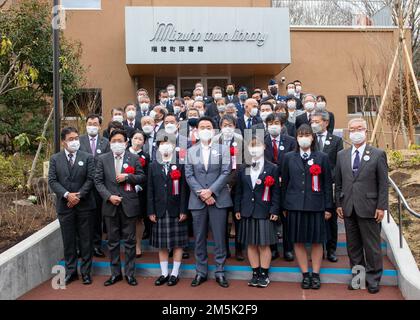 Hiroyuki Sugiura, maire de la ville de Mizuho, avec des élèves des écoles locales et d'autres invités d'honneur, se préparent à couper le ruban d'ouverture lors d'une cérémonie de réouverture de la bibliothèque de la ville de Mizuho, Japon, 21 mars 2022. Le colonel Philip Dorsch, commandant du groupe de maintenance 374th, et le chef-maître Sgt Damon Yarborough, 374th MXG, chef de file inscrit, étaient les invités de l'événement de réouverture, où l'installation récemment rénovée comprenait une section consacrée à la relation étroite de la ville avec la base aérienne de Yokota. Banque D'Images