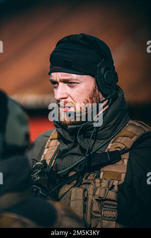 Un Marinier de Korps avec le Royal Netherlands Marine corps dirige le personnel et l'équipement hors d'une zone d'atterrissage sur la plage pendant l'exercice Cold Response 22 à Sandstrand, Norvège, 21 mars 2022. L'exercice Cold Response 22 est un exercice biennal de préparation nationale et de défense de la Norvège, avec la participation de chacun de ses services militaires, dont 26 pays alliés de l'Organisation du Traité de l'Atlantique Nord (OTAN) et partenaires régionaux. Banque D'Images