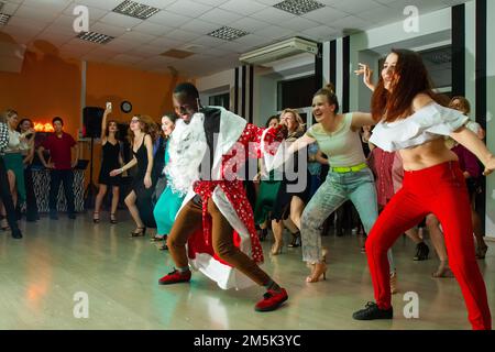 23-12-2022 Moscou, Russie. Professeur de danse afro-russe joue Ded Moroz (Père Noël. Grandfather Frost) et danse aussi avec le groupe - ils regardent t Banque D'Images