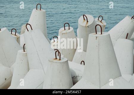 Gros plan de la pile de tétrapodes blancs en béton marin près de la mer Banque D'Images