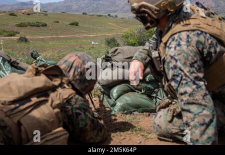 ÉTATS-UNIS Le sergent Kyle Lamb, à droite, un chef d'équipe avec peloton de Sniper Scout, 2nd Bataillon, 1st Marine Regiment, 1st Marine Division, instruit un compagnon Marine en tirant sur un système semi-automatique de sniper M110 pendant une période d'entraînement de rupture de munitions stand-off à la gamme 408 sur le camp de base du corps de Marine Pendleton, 21 mars, 2022. SMUD est une technique utilisée par les techniciens d'élimination des munitions explosives pour neutraliser rapidement et efficacement les munitions à une distance de sécurité. Lamb est originaire de Parker, Kansas. Banque D'Images