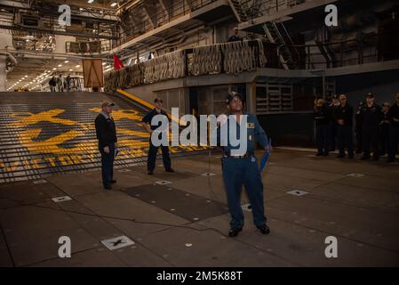 220321-N-XB010-1001 SASEBO, Japon (21 mars 2022) le chef de commandement Edward Bazile s'adresse aux marins de l'USS New Orleans (LPD 18) dans le pont de puits du navire lors d'un appel à mains libres. La Nouvelle-Orléans, qui fait partie de l'America Amphiobie Ready Group, ainsi que de l'unité expéditionnaire maritime 31st, opère dans la zone de responsabilité de la flotte américaine 7th afin d'améliorer l'interopérabilité avec les alliés et les partenaires et de servir de force de réaction prête à l'emploi pour défendre la paix et la stabilité dans la région Indo-Pacifique. Banque D'Images