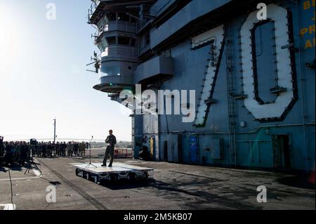 220322-N-TL932-1008 SAN DIEGO (22 mars 2022) le capitaine Ryan Jackson, dirigeant du porte-avions de la classe Nimitz USS Carl Vinson (CVN 70), s'adresse aux marins lors d'un appel à mains libres sur le pont de vol, 22 mars. Vinson est actuellement à pierside dans son homeport de San Diego. Banque D'Images