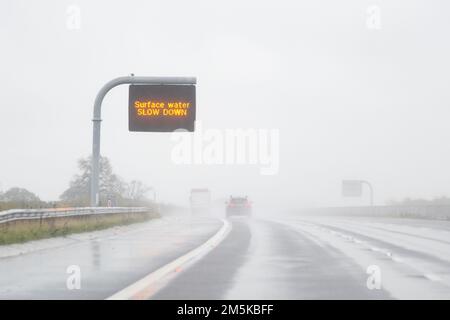 L'eau de surface RALENTIT le PANNEAU de message variable sur l'autoroute du Royaume-Uni en cas de forte pluie Banque D'Images