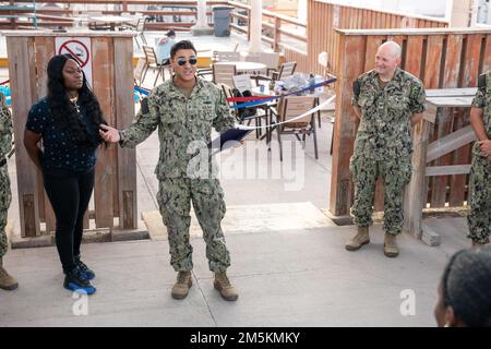 CAMP LEMONNIER, Djibouti (23 mars 2022) Spécialiste du personnel 1st classe Jesus A. Salazar, président du Comité de diversité et d'inclusion des forces interarmées sur le Camp Lemonnier, Djibouti (CLdJ), prononce un discours lors d'une coupe de ruban pour célébrer la réussite du Comité de la diversité à devenir une entité non fédérale (NFE), Une organisation autonome sur la base, comme les États-Unis Le capitaine de la Marine, David Faehnle, commandant du Camp Lemonnier, regarde dessus. Le CLDJ sert de base expéditionnaire pour les forces militaires américaines fournissant un soutien aux navires, aux aéronefs et au personnel qui assurent la sécurité dans toute l'Europe, Afrique an Banque D'Images