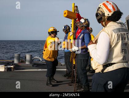 OCÉAN ATLANTIQUE (22 mars 2022) – le Mate 2nd de Boatswain classe Alyssa Mullinax, à gauche, montre que tous les craies et chaînes ont été enlevés avant qu'un MH-60R Seahawk puisse décoller du pont de vol du destroyer à missiles guidés de classe Arleigh Burke USS porter (DDG 78), 22 mars. Porter, déployé à Rota, en Espagne, participe actuellement à l'exercice du groupe de travail dans la zone d'exploitation de la flotte américaine 2nd. Le TTEX sert d'exercice de certification pour le déploiement indépendant des navires et est conçu pour tester la préparation et le rendement de la mission dans les opérations intégrées. Banque D'Images