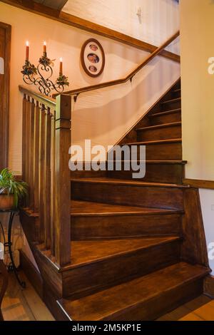 Escalier en bois menant à l'étage supérieur dans le salon à l'intérieur d'une maison en rondins résidentielle reconstruite des années 1840. Banque D'Images