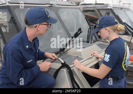 ÉTATS-UNIS Gardien de la côte Agent du Petty 3rd classe Justin Hodnet, à gauche, et Agent du Petty 3rd classe Sarah Holt, techniciens en machinerie (MK) affectés à la station Mayport, Floride, changer les balais d'essuie-glace sur un bateau de réponse de station-petit, 23 mars 2022. Les MKS travaillent dans tous les domaines de l'exploitation et de la maintenance des machines, des moteurs à combustion interne aux systèmes de soutien à l'environnement, aux systèmes hydrauliques, à l'électricité de base et aux zones de récupération et de contrôle des matières dangereuses. Banque D'Images