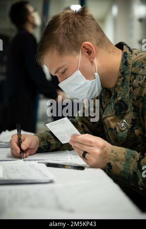 OCÉAN ATLANTIQUE - Hôpital Corpsman 3rd classe Jacob Keeton vérifie une carte de vaccination COVID-19 à bord du navire d'assaut amphibie de classe Wasp USS Kearsarge (LHD 3) 23 mars 2022. Le Kearsarge Amphiobie Ready Group avec embarqué 22nd Marine Expeditionary Unit est en cours de déploiement prévu dans la zone d'exploitation de la flotte américaine 2nd. Banque D'Images