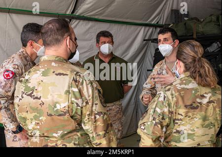 Les partenaires de la coalition de la Force aérienne italienne s'entretient avec les membres du 405th Escadron expéditionnaire d'évacuation aérienne, à la base aérienne Ali Al Salem, au Koweït (23 mars 2022). Le but de la journée portes ouvertes était de présenter les capacités, les processus et la mise en place de l'avion C-130 Hercules aux homologues partenaires de la coalition. Banque D'Images