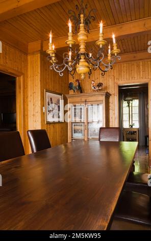 Longue table à manger et chaises dans la salle à manger à l'intérieur de l'ancienne maison de style cottage 1920s. Banque D'Images