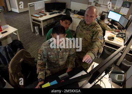 BASE DE LA FORCE SPATIALE PETERSON, COLORADO – ÉTATS-UNIS Le Sgt. Principal de la Force aérienne, Johnathan Mollison, 21st, escadron de contrôleur, chef principal inscrit, à droite, et aux États-Unis Tech. De la Force aérienne Le Sgt Juan Antonio, 21st CPT, officier non commandant en charge des opérations financières, à gauche, montre Airman 1st classe Eughine Garing, 21st CPT, technicien des opérations financières, Middle, comment mettre à jour les registres de paye à la base spatiale Peterson, Colorado, 18 mars 2022. Mollison assure la formation et le développement appropriés des 21st TROUPES DU CPT, permettant ainsi le soutien de la mission de garnison Peterson-Schriever. Banque D'Images