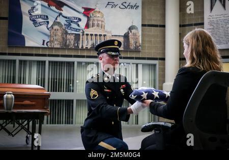 Un soldat de la Garde nationale de l'armée de l'Iowa présente un drapeau américain à un étudiant en affaires mortuaires lors d'une manifestation commémorative de la Garde d'honneur au quartier général de la Force interarmées à Johnston, Iowa, on 3 mai 2022. Les membres de la Garde d'honneur se sont associés au Collège communautaire de la région des Moines à Ankeny pour éduquer les étudiants en affaires mortuaires. Banque D'Images