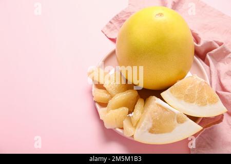 Assiette de fruits au pomelo et tranches sur fond rose, gros plan Banque D'Images