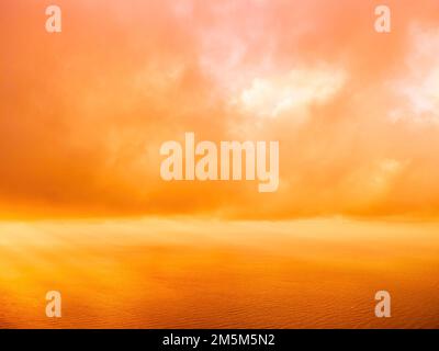 Vue aérienne coucher de soleil rouge sur la mer avec falaise volcanique rocheuse. Résumé nature été coucher de soleil océan mer fond. Petites vagues sur doré chaud Banque D'Images