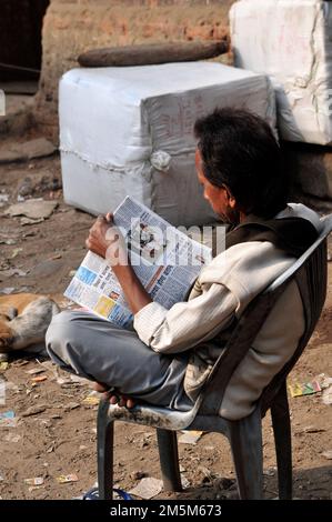 Un homme bengali lisant le journal du matin à Kolkata, en Inde. Banque D'Images