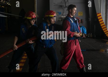 Les marins affectés au service technique de l’USS Gerald R. Ford (CVN 78) participent à l’essai de tuyaux hydrostatiques dans la baie hangar de Ford, en 24 mars 2022. Ford est en cours dans l’océan Atlantique en menant la certification de plate-forme de vol et la qualification de transporteur aérien dans le cadre de la phase de base sur mesure du navire avant le déploiement opérationnel. Banque D'Images