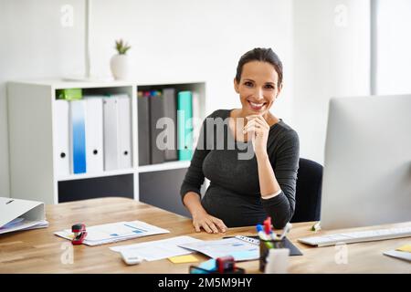 Une lueur positive au bureau. Portrait d'une femme d'affaires enceinte travaillant dans un bureau. Banque D'Images