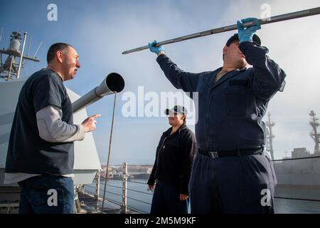 De gauche à droite : Mark (MK) 110 Agent de génie en service Aleksandr Konstantinovsky avec le Naval surface Warfare Center, division Port Hueneme, Brenda Reis, chef du compagnon de Gunner, et Jacob Kolesik, maître du compagnon de classe 2nd de Gunner, travaillent ensemble pour éliminer les obstructions du tunnel de l’arme à plate-forme MK 110 à bord de l’USS Kansas City (LCS 22) lors d’un événement d’évaluation et de maintenance de l’équipe d’évaluation des systèmes de combat au centre de guerre. Banque D'Images